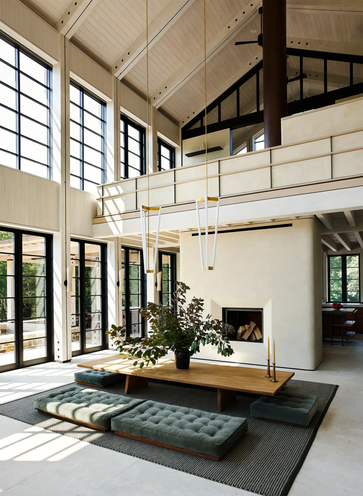 Low dining table with cushion seating under a gallery level