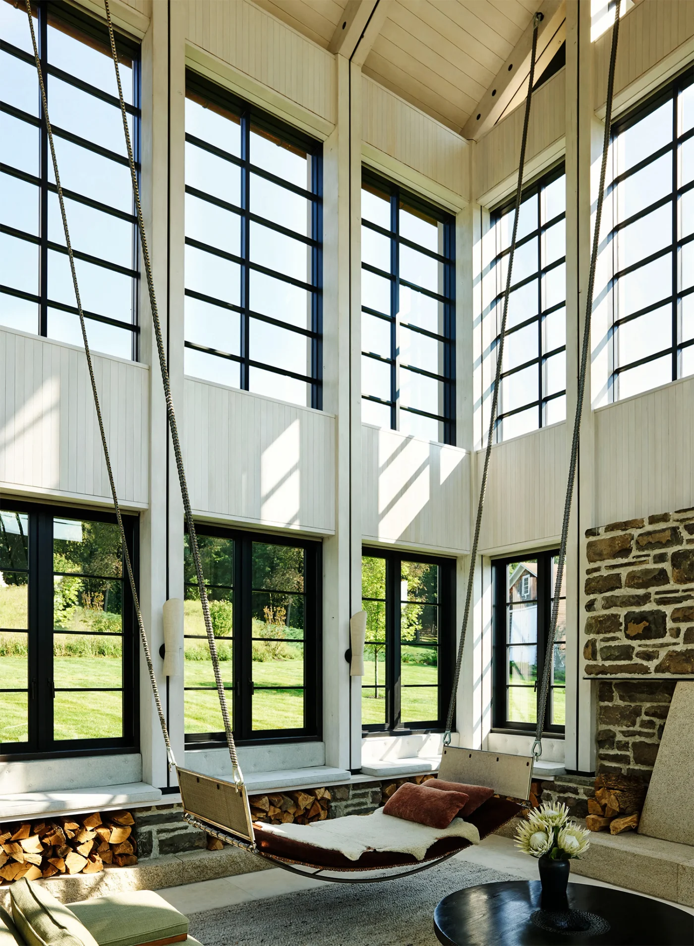 Hanging daybed suspended on long chains in the double-height living space