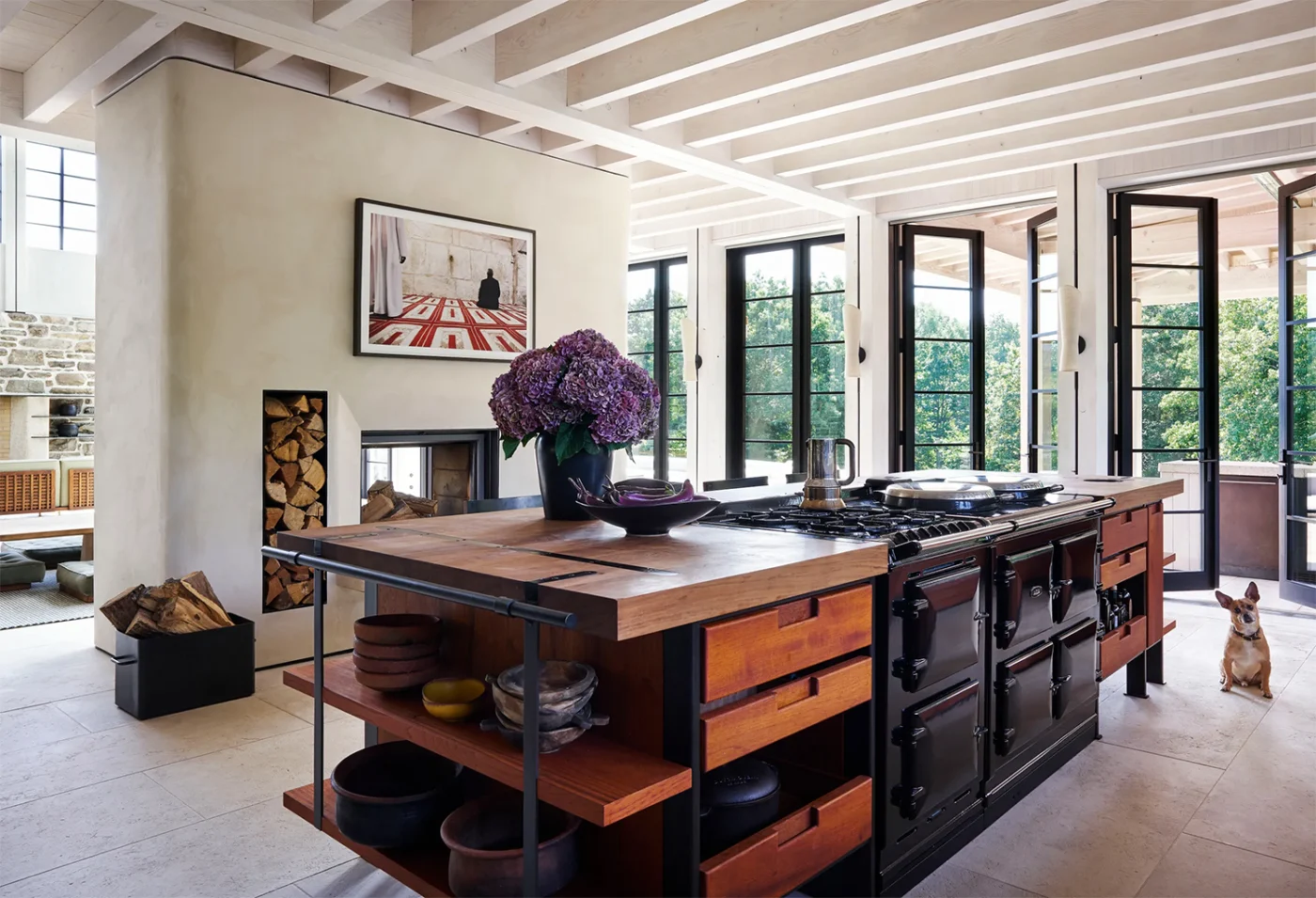 Kitchen with a wood and steel island beside a fireplace wall