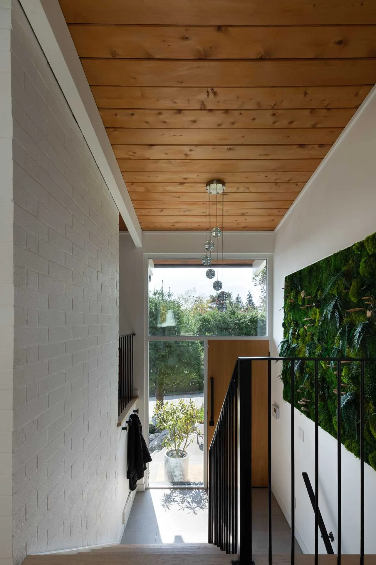 Updated entryway with a wood ceiling, white wall and green accent wall