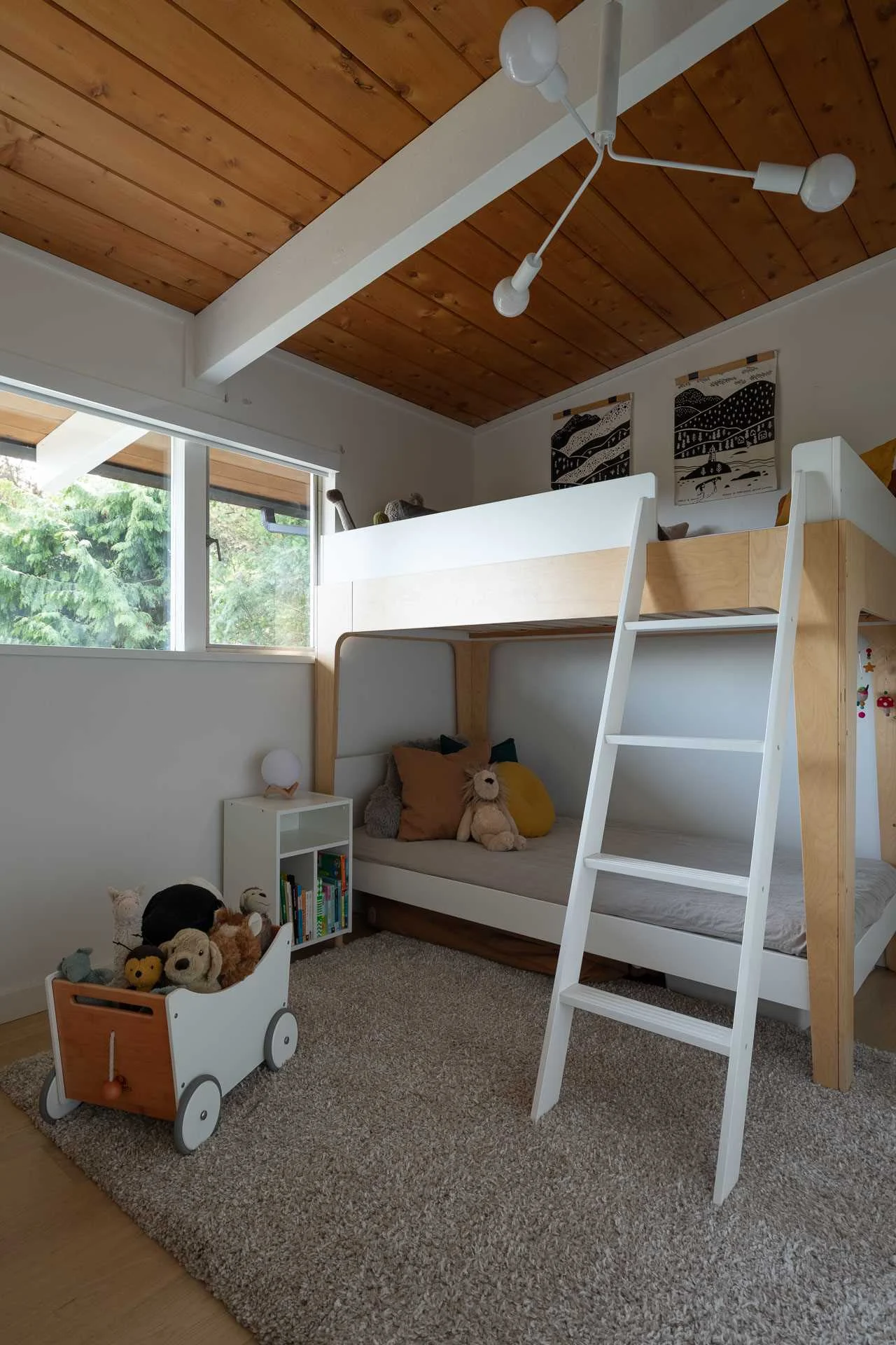 Children's bedroom with white walls, white beams and a bunk bed