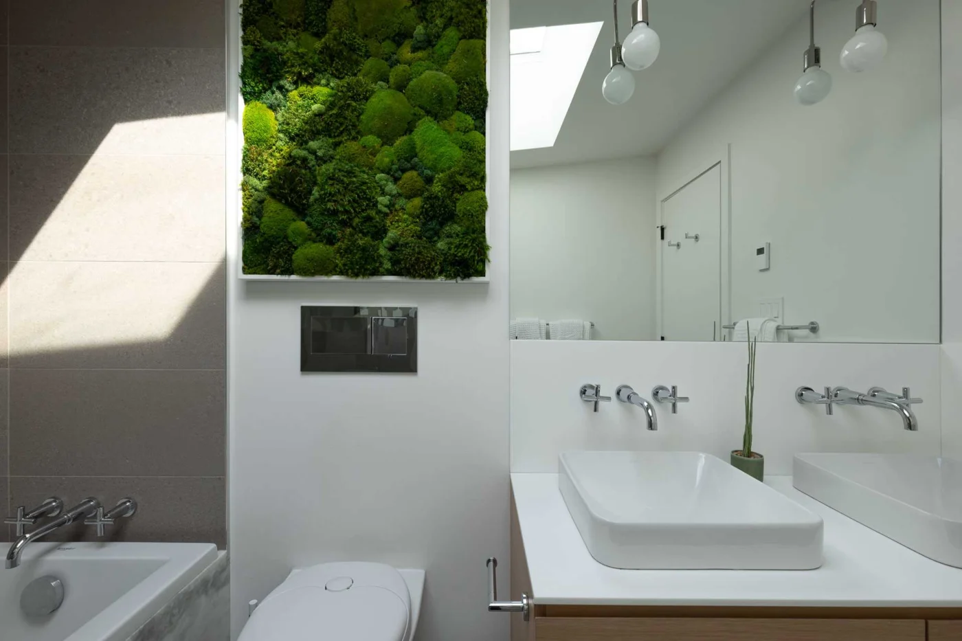 Remodeled bathroom with large-format tiles and a wall-mounted toilet