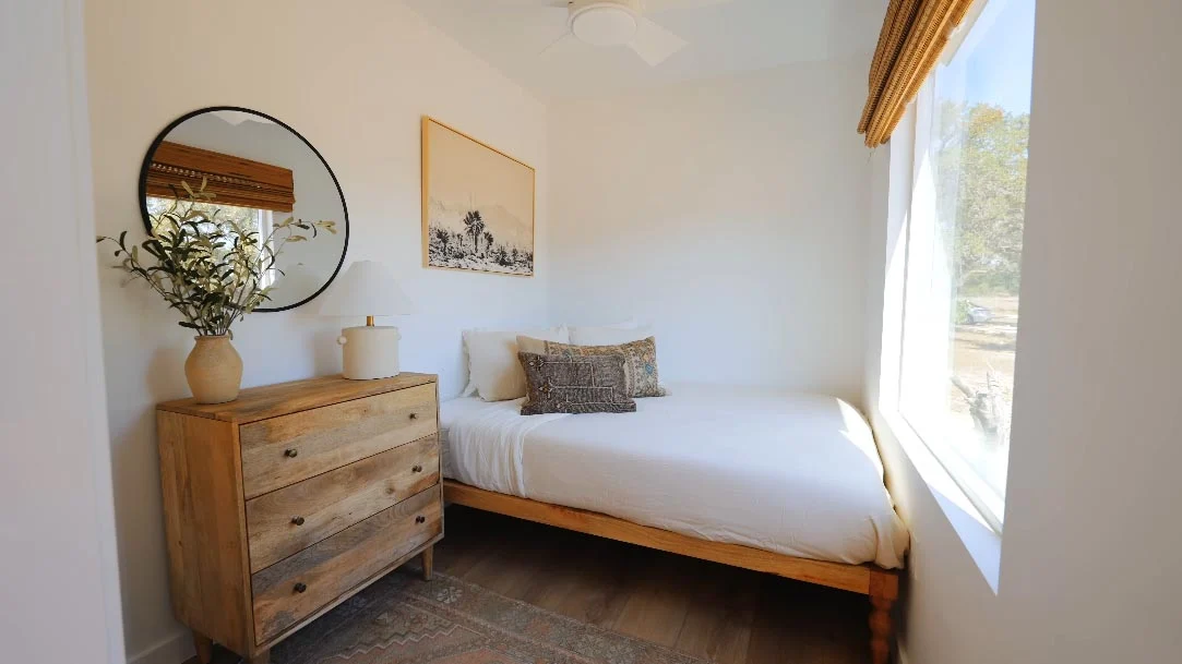 Minimal bedroom with a bed, chest of drawers and picture window