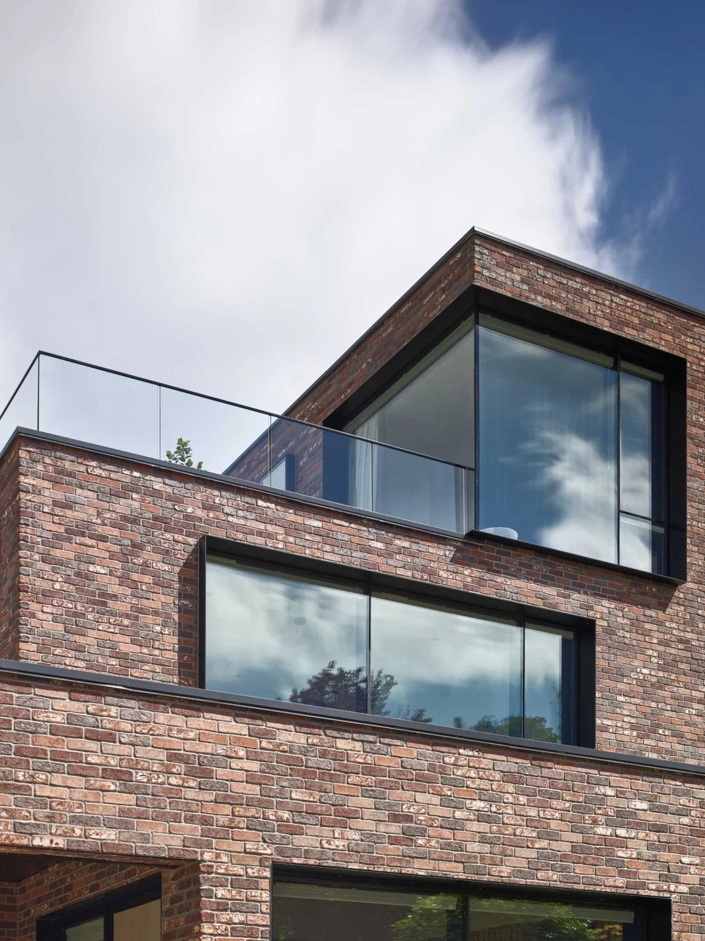 Brick facade with black metal soffits and protruding window frames
