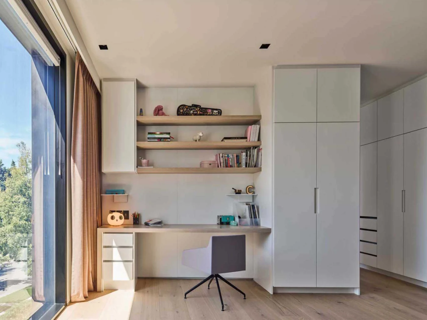 Bedroom with a built-in study desk and floating shelves