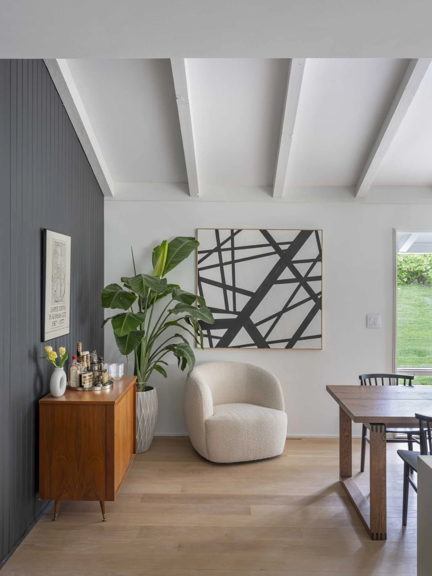 Former living room turned into a bright dining room with a grey accent wall and wood floors