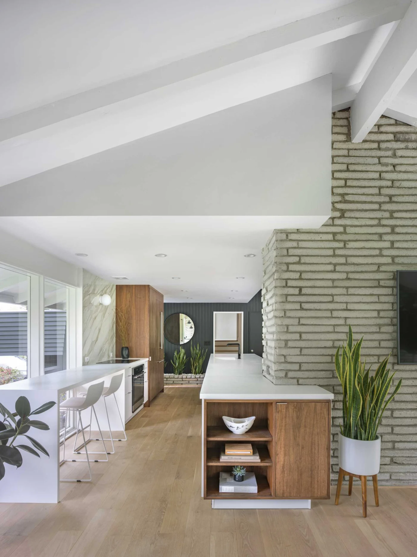 Open kitchen with long white countertops and wood cabinets