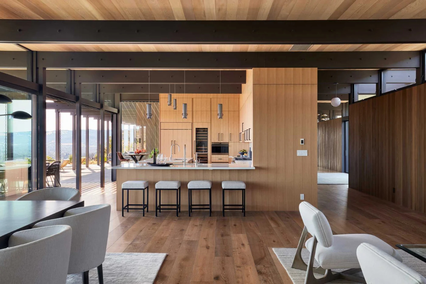 Wood kitchen with tall cabinets, pendant lights and light-coloured counters