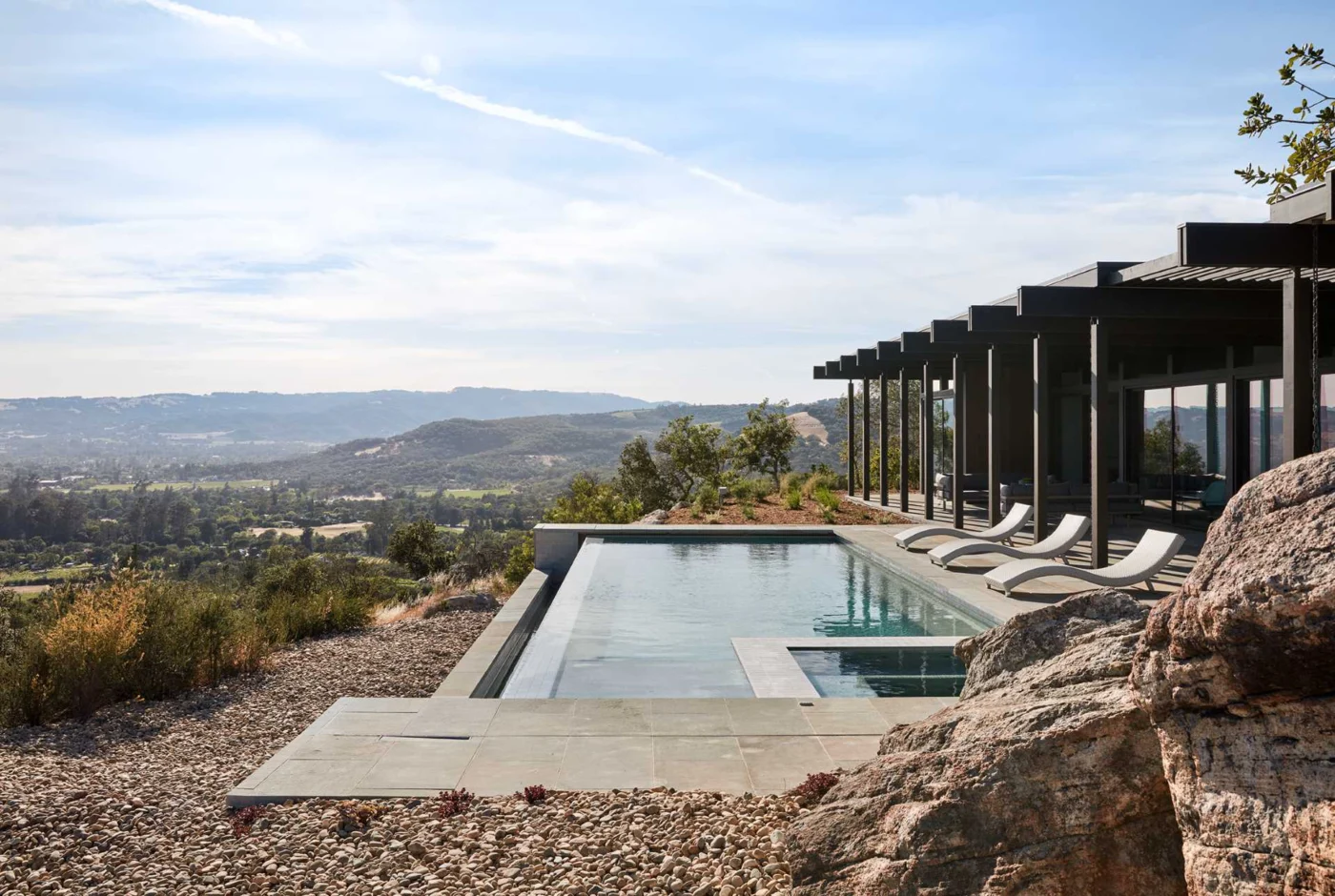 Infinity-edge swimming pool beside the mid-century inspired house