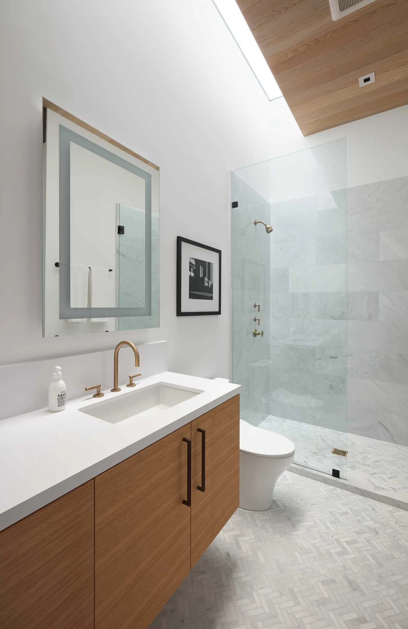Bathroom with wood accents, light tiles and a skylight
