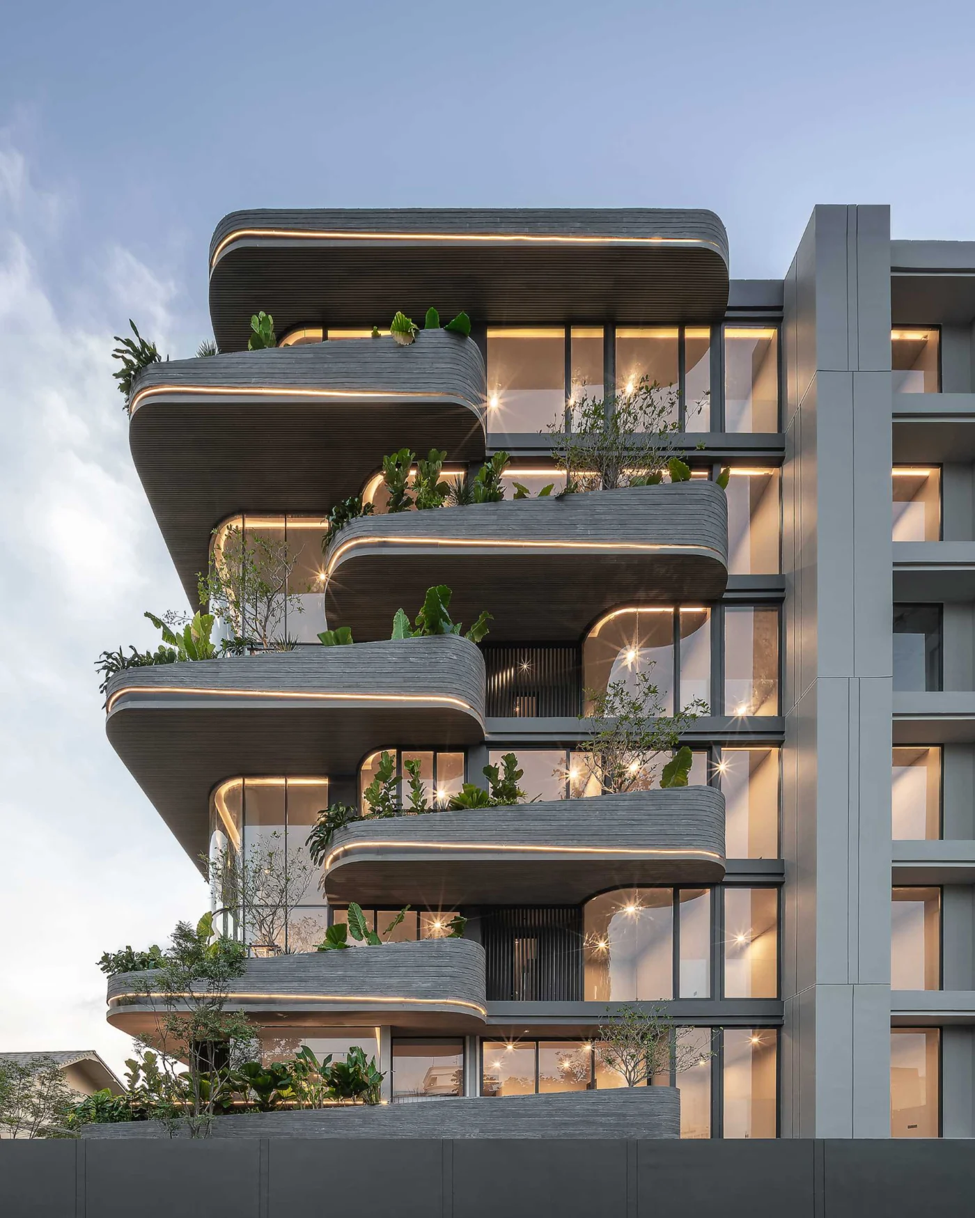 Exterior lighting tracing the curved shape of the Bangkok condo