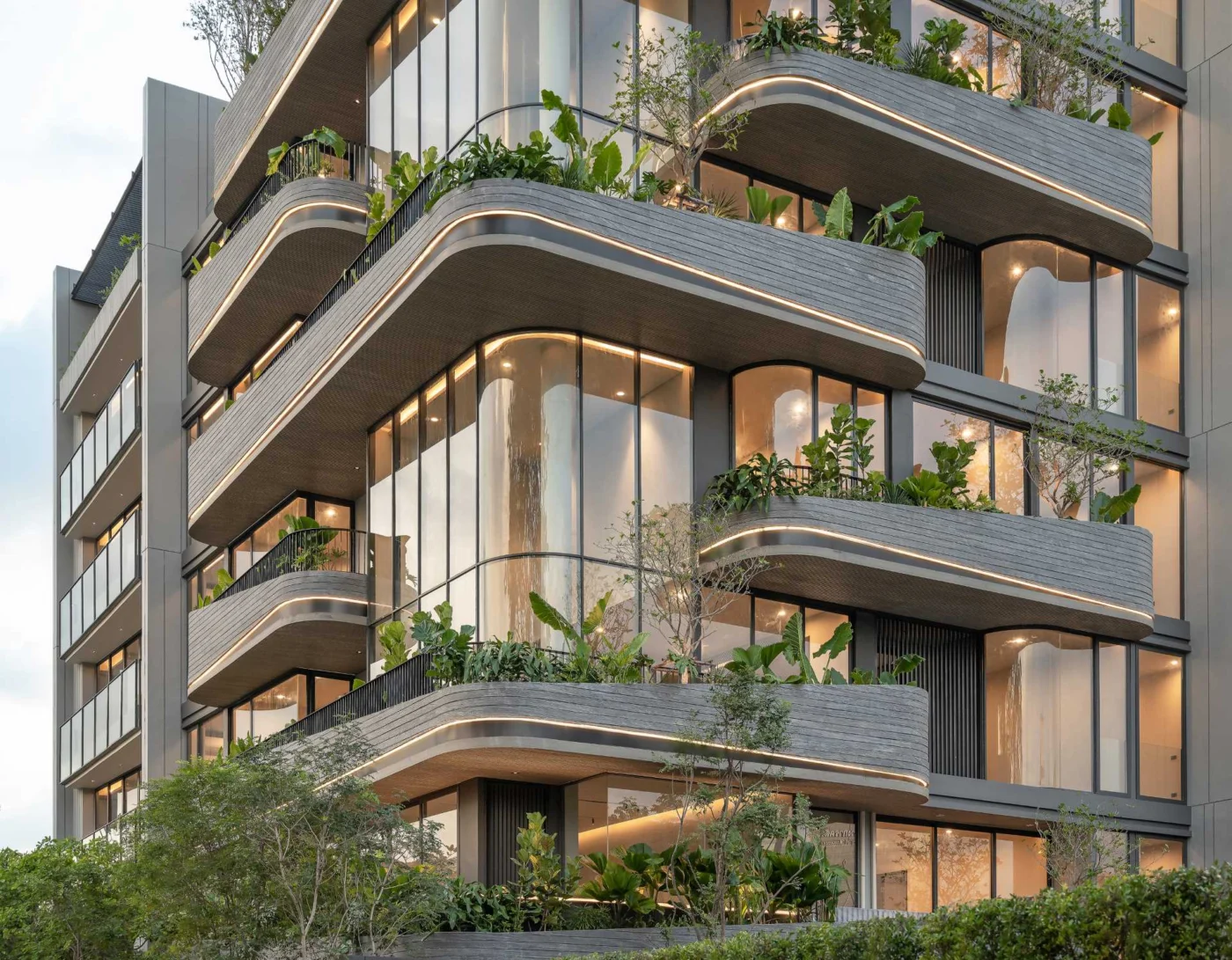 Lit rounded balconies of the Kalm Penthouse Ari building in Bangkok