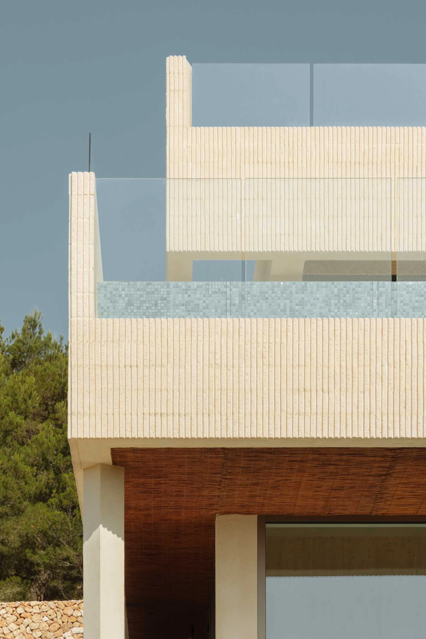 Fluted concrete walls and teak carpentry on the villa exterior