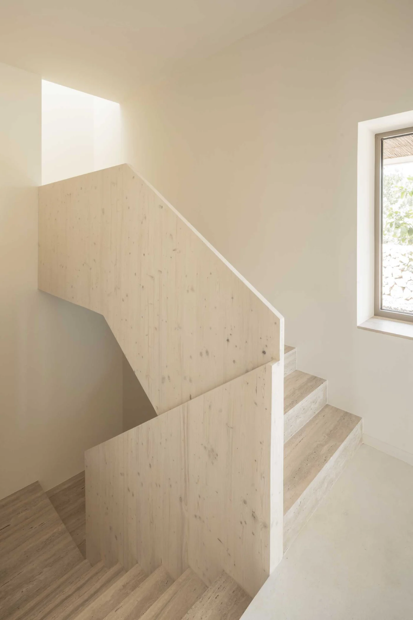 Travertine steps and polished white concrete floor between white walls