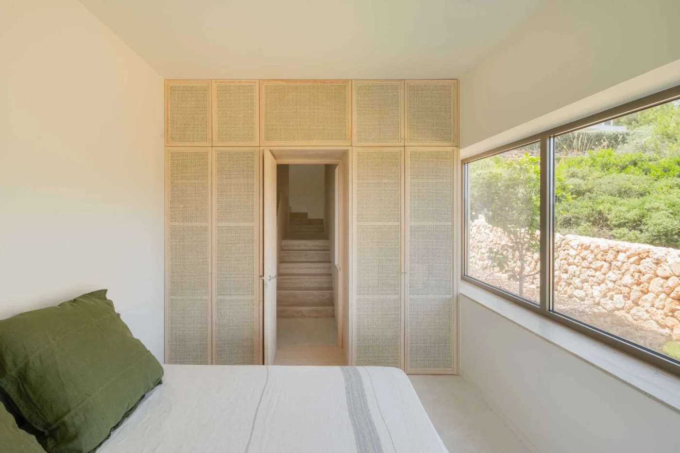 Bedroom with rattan and light pine joinery