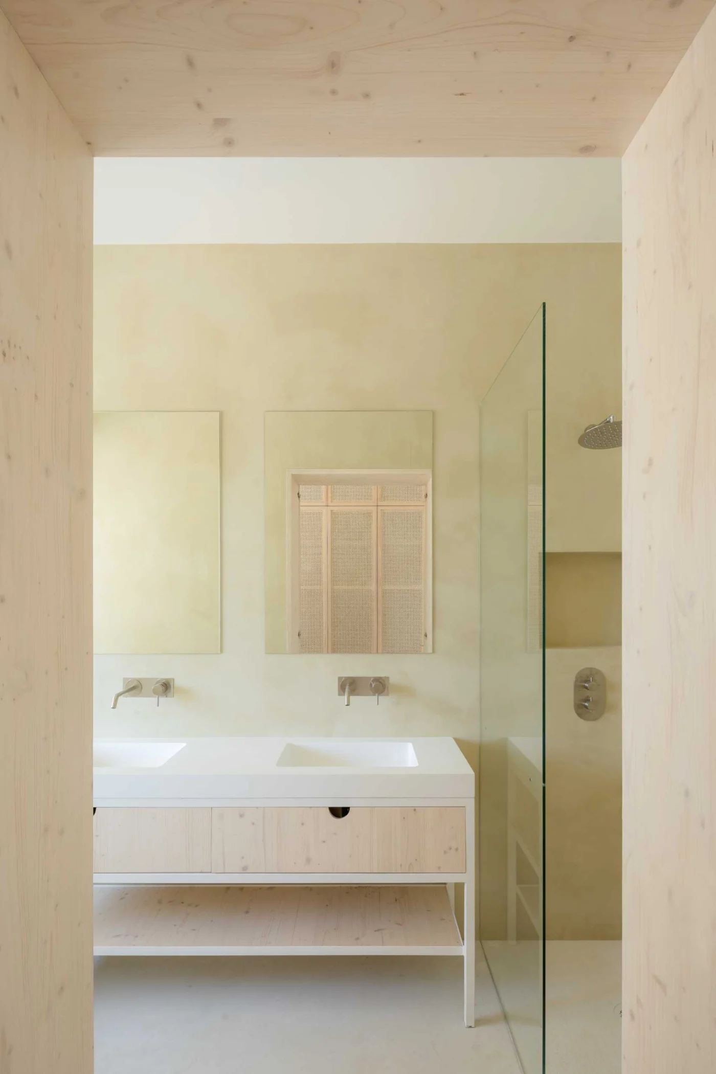 Bathroom finished in khaki-beige micro-cement with a white vanity