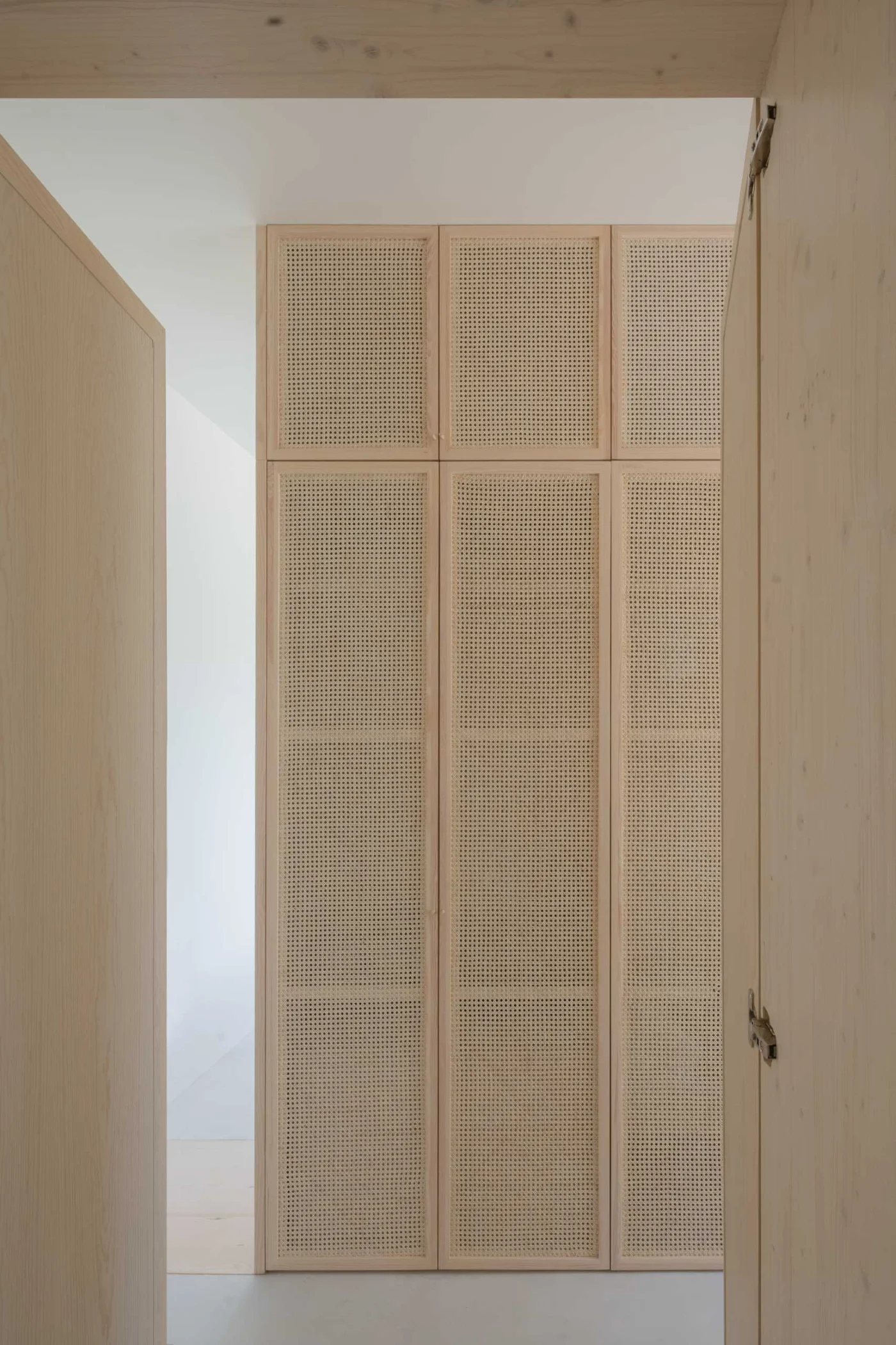 Walk-in wardrobe with artisanal rattan and light pine carpentry