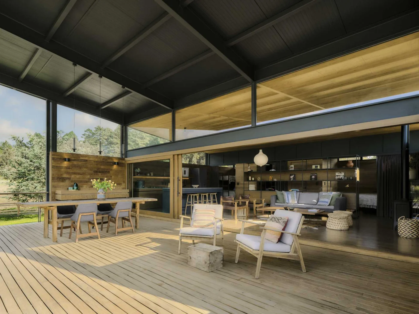Double-height covered terrace opening to the living room through sliding glass doors