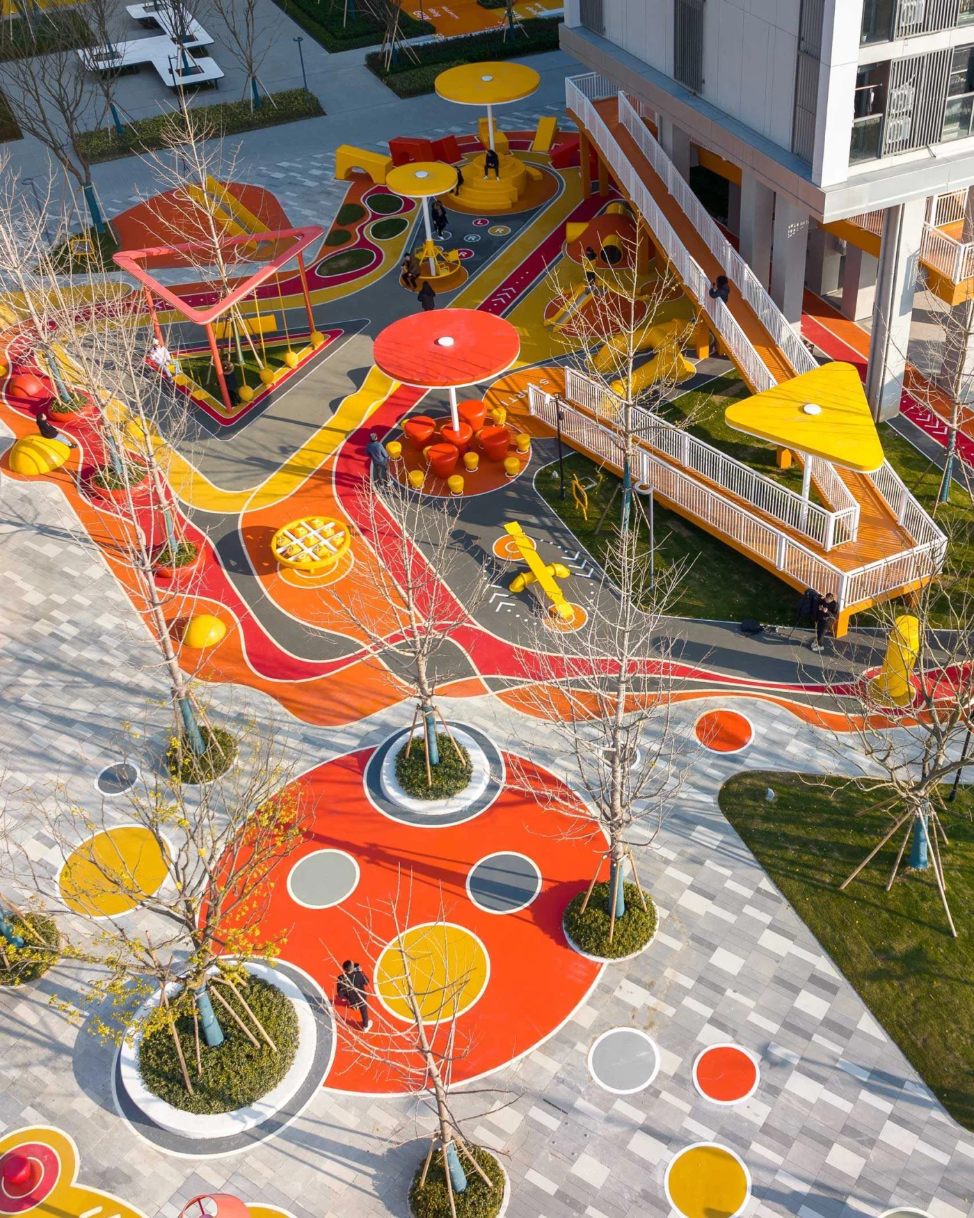 Orange ramp rising from the park towards a residential building