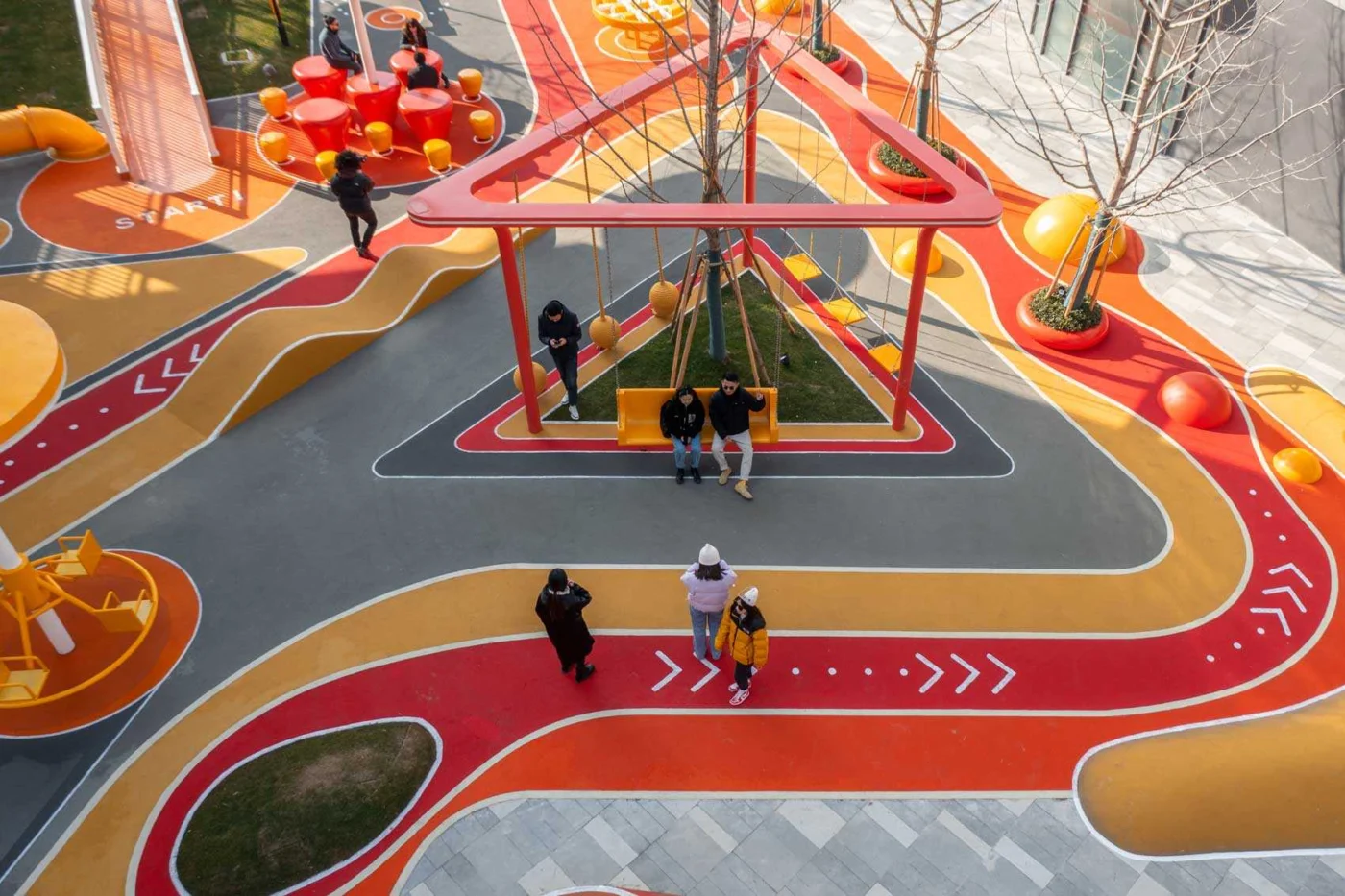 Aerial view of the triangular swing set among wavy paths and trees