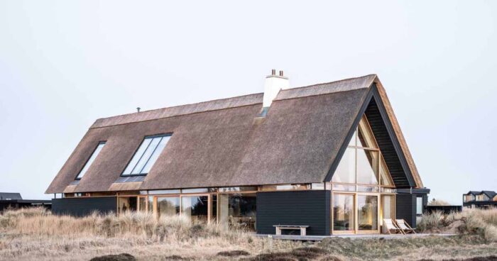 a-thatched-roof-and-charred-wood-siding-were-used-to-create-this-modern-home