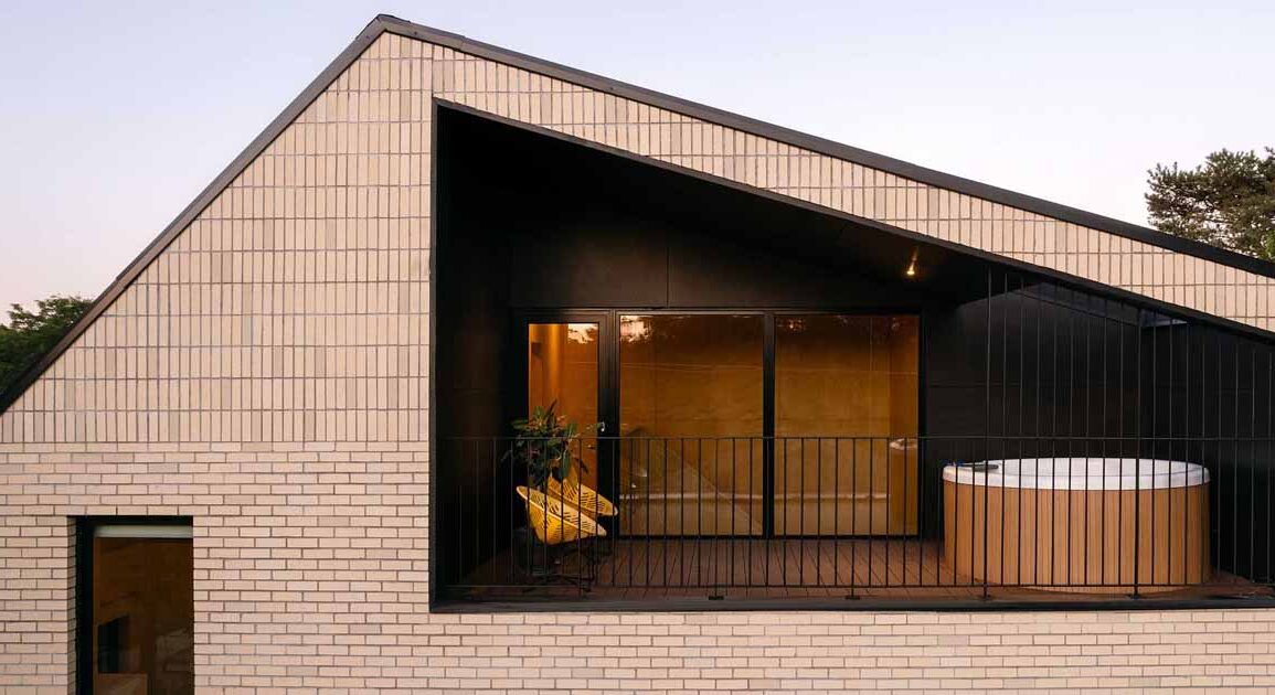 a-sheltered-space-beneath-the-sloping-roof-of-this-home-makes-space-for-a-hot-tub