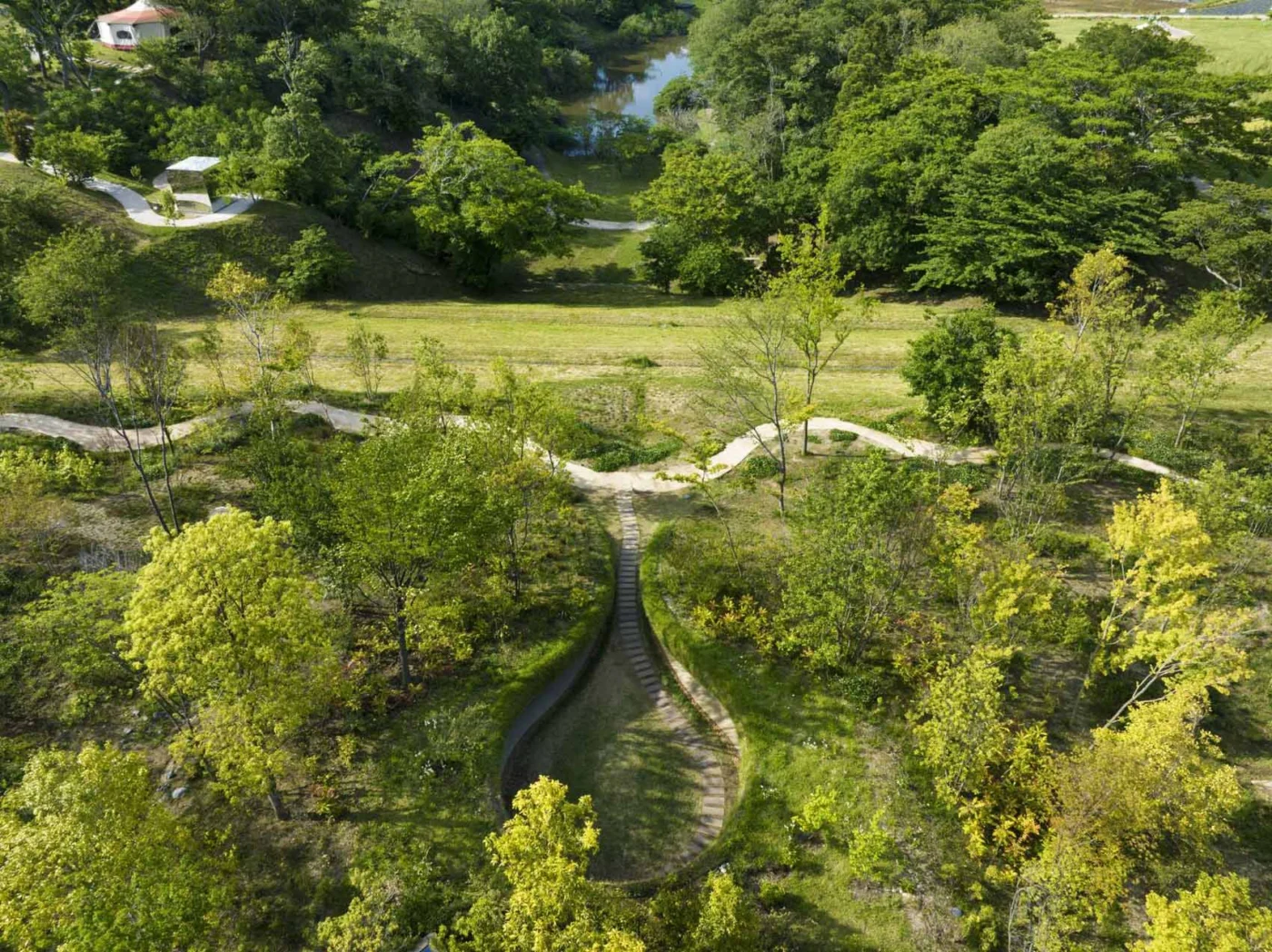 Aerial view of the water-drop-shaped cleft among trees and fields