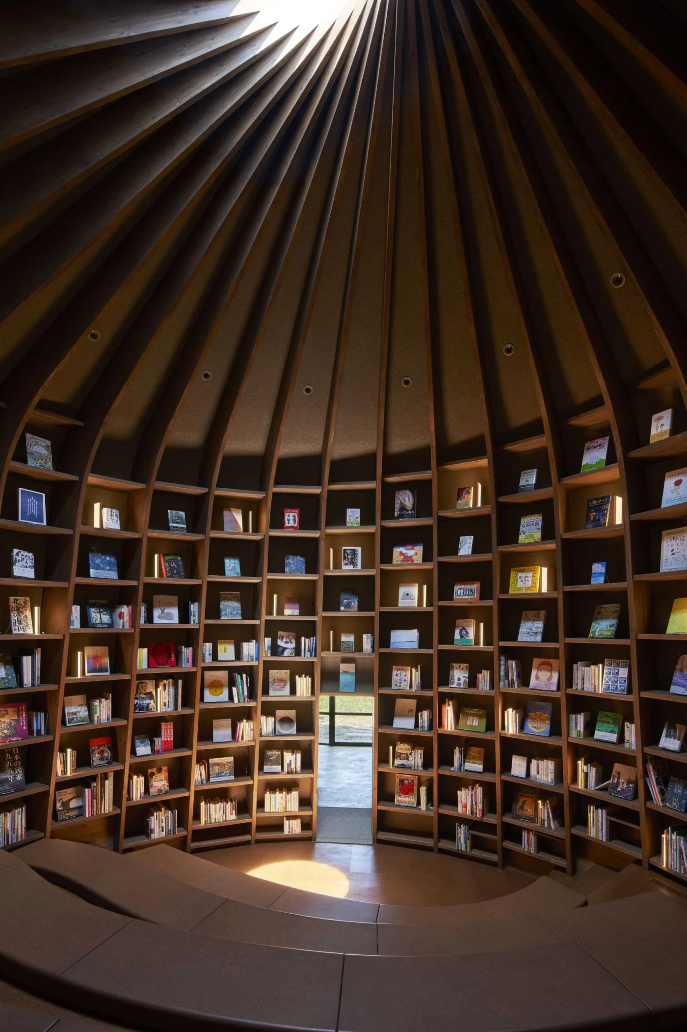 Storytelling hall with shelves rising towards a central skylight