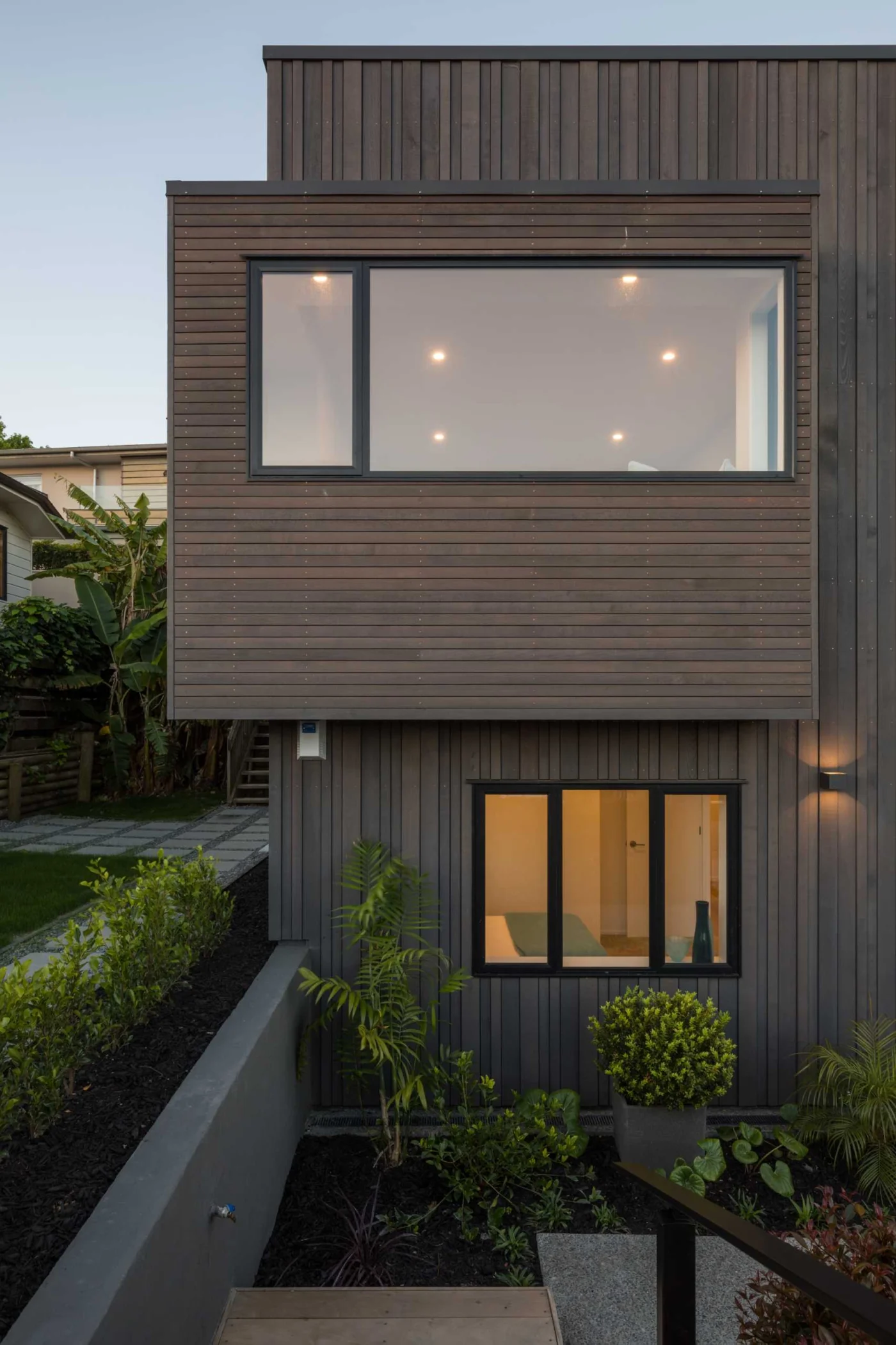 Dark wood cladding laid horizontally and vertically with black window frames