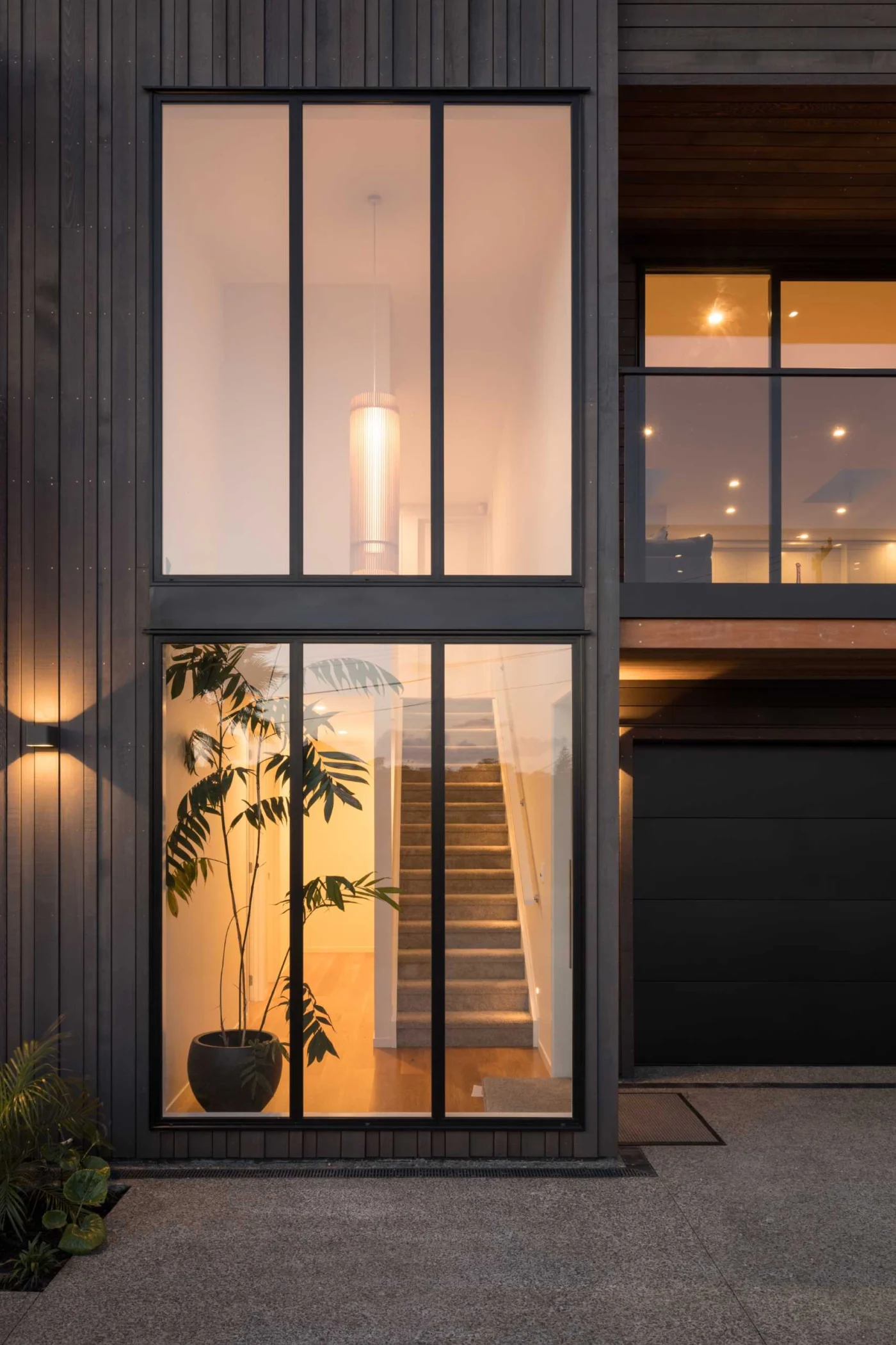 Tall windows glowing with interior light in the evening