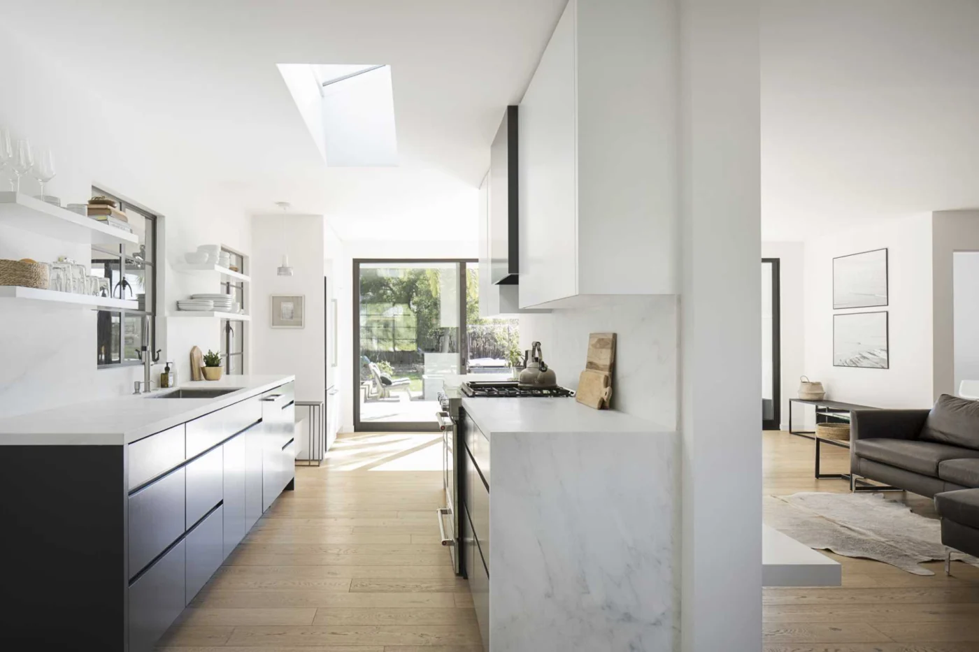 Kitchen with matte black and white cabinets and floating white shelves