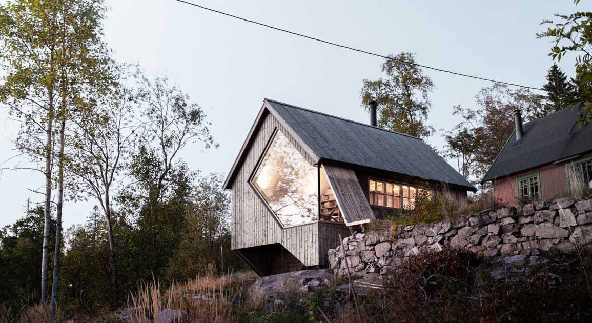 a-unique-window-shape-helps-frame-the-view-from-inside-this-cabin