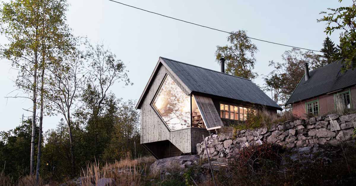 a-unique-window-shape-helps-frame-the-view-from-inside-this-cabin