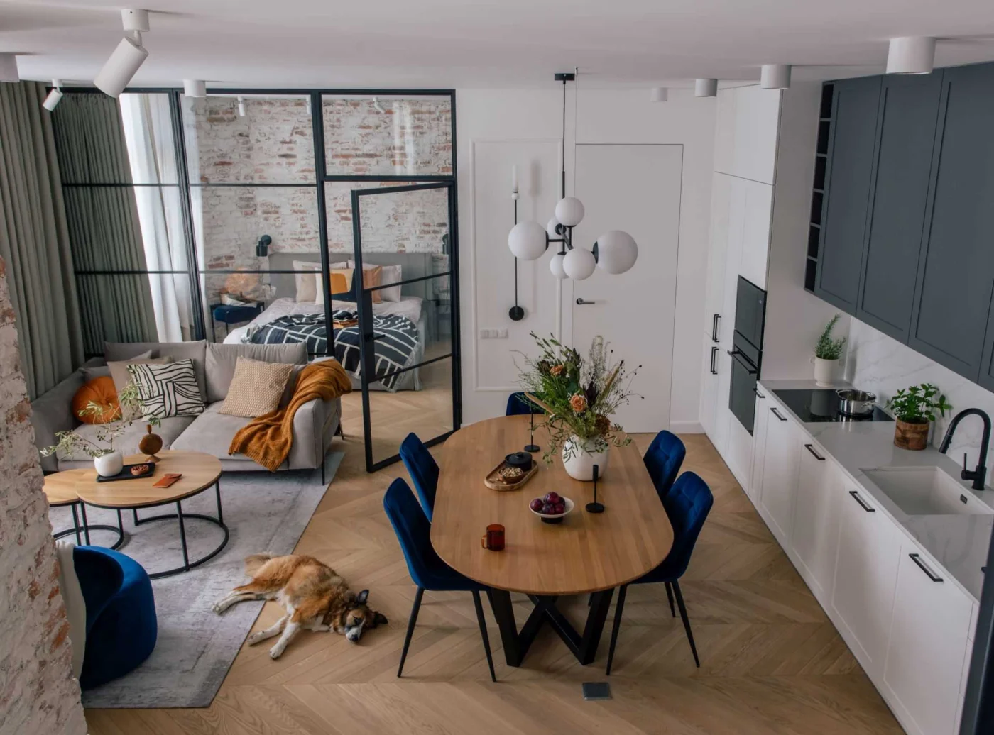 A Glass Wall Separates a Bedroom From the Living Spaces in This Apartment