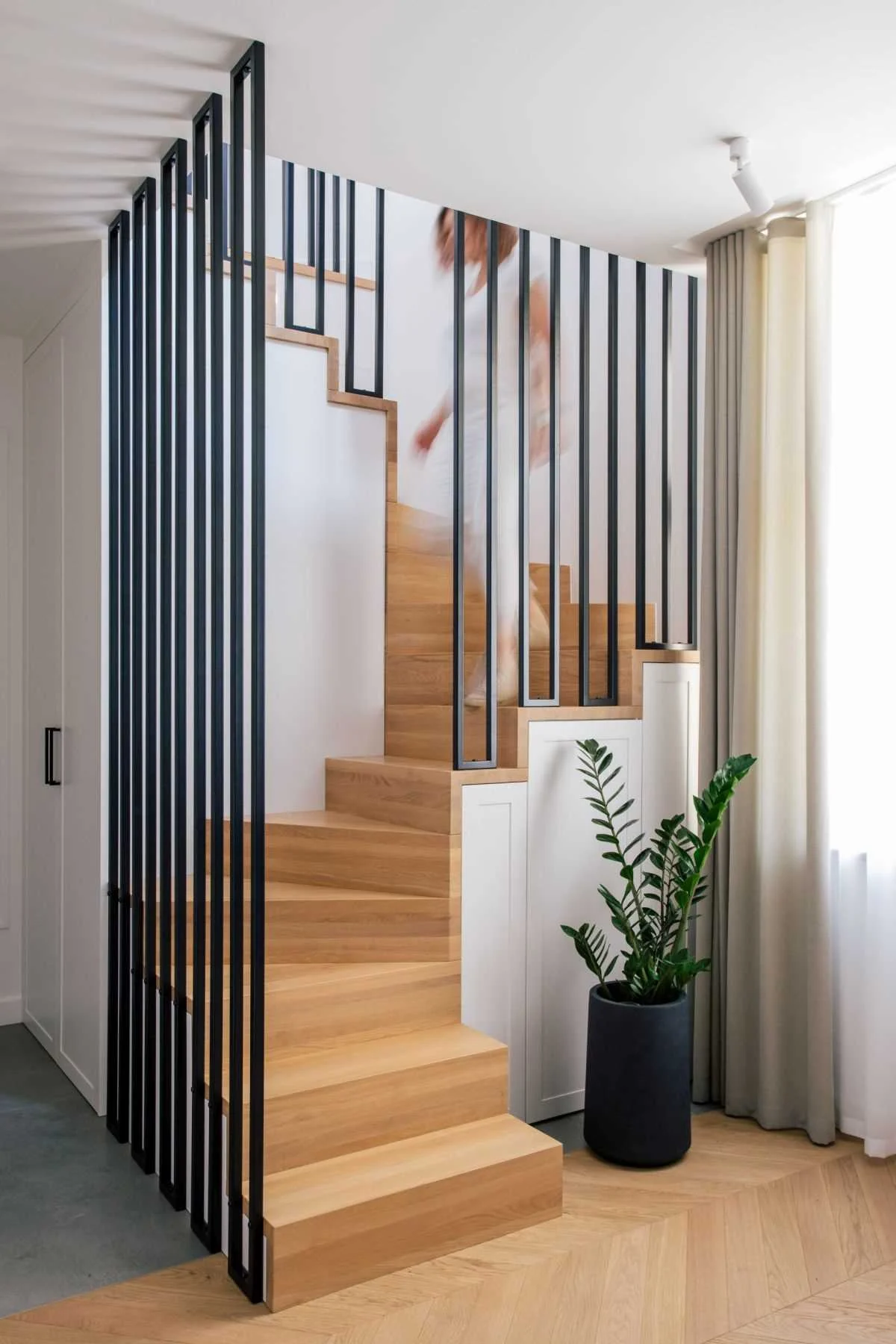 Wood stairs with black metal details leading to the upper floor