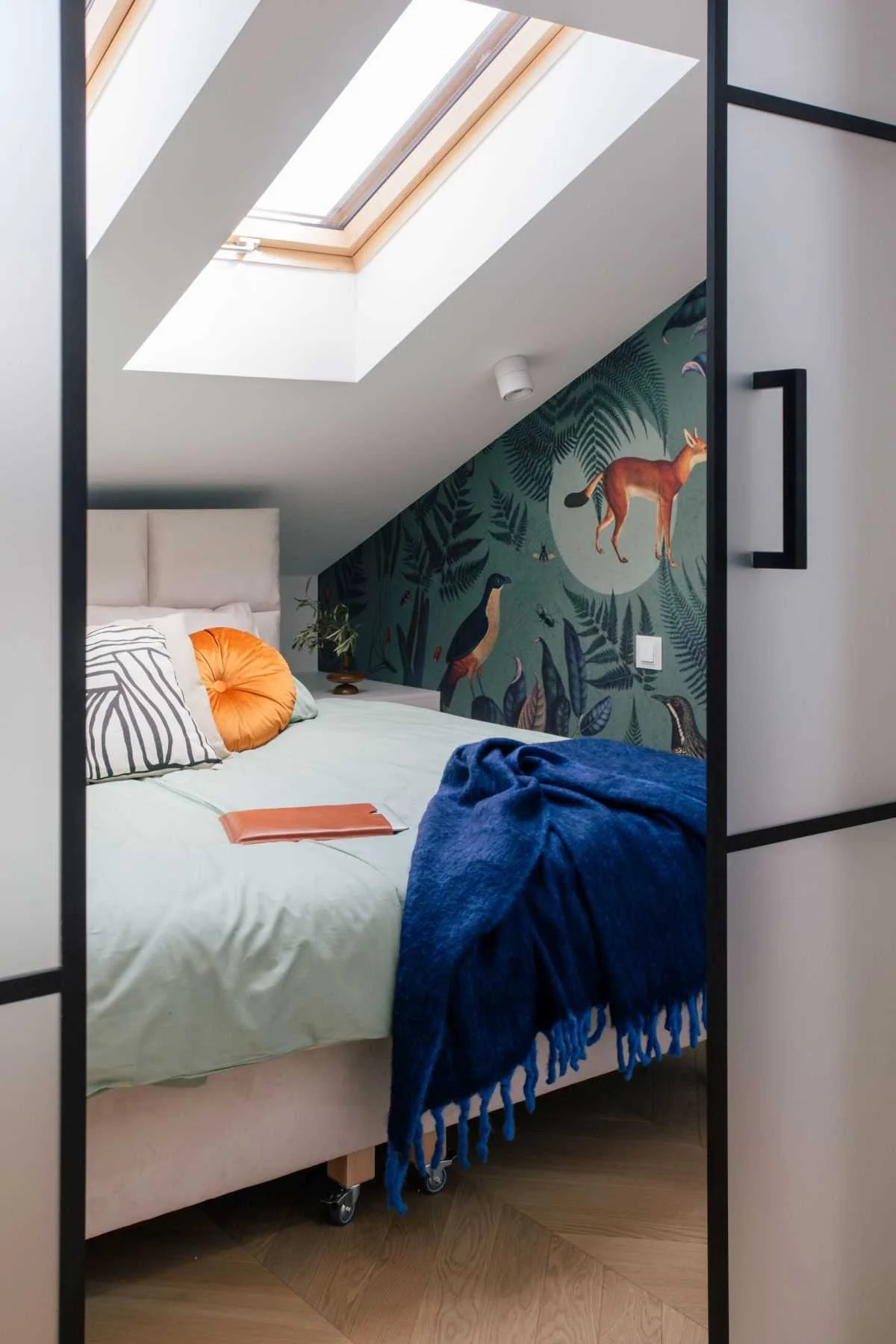 Upstairs bedroom with skylights and wallpaper of botanicals, birds and animals