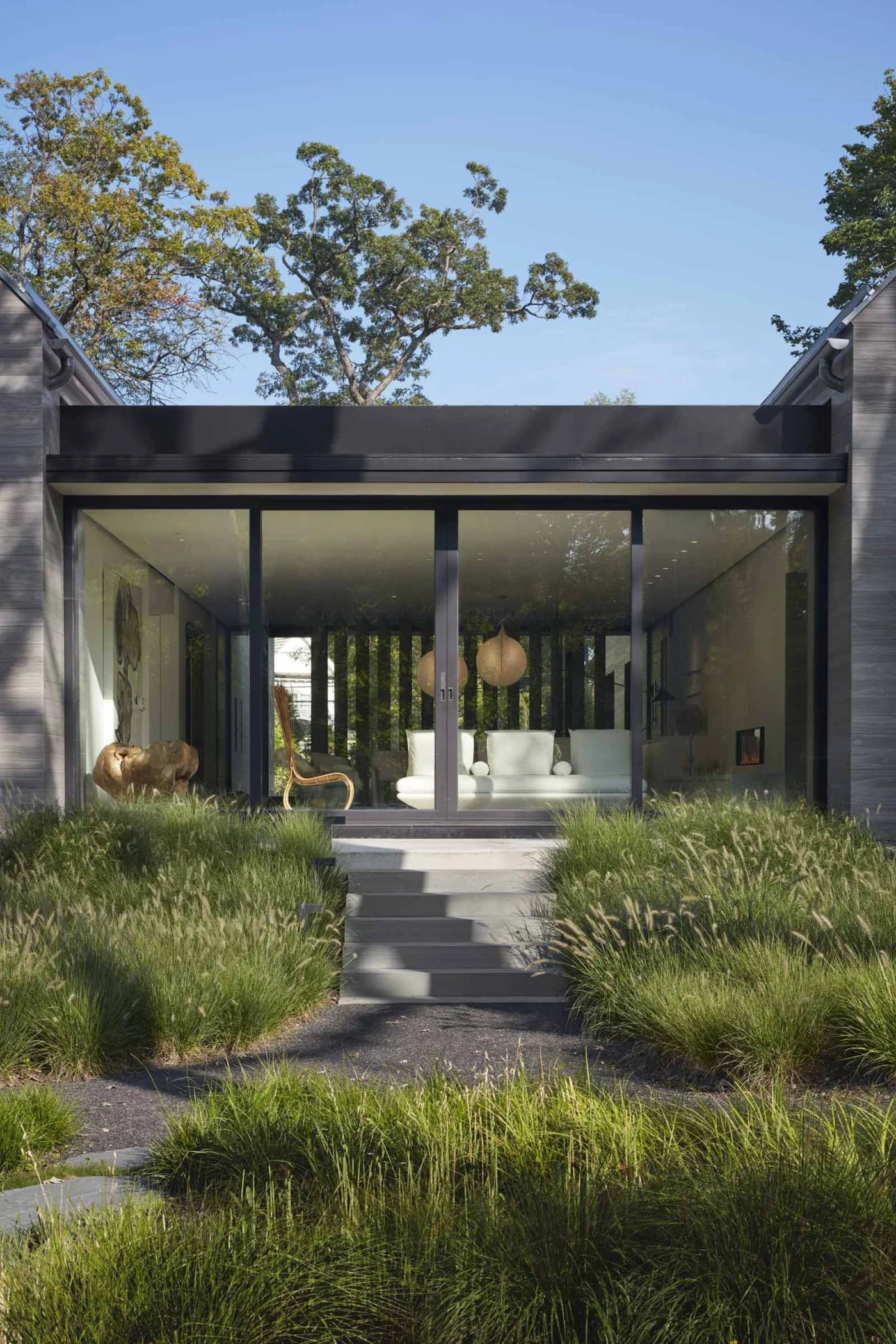 Sliding glass doors opening the breezeway to outdoor stairs among grasses