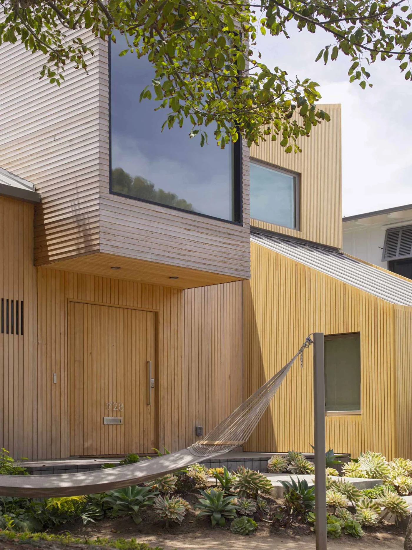 Front door set into the cedar facade under a projecting volume