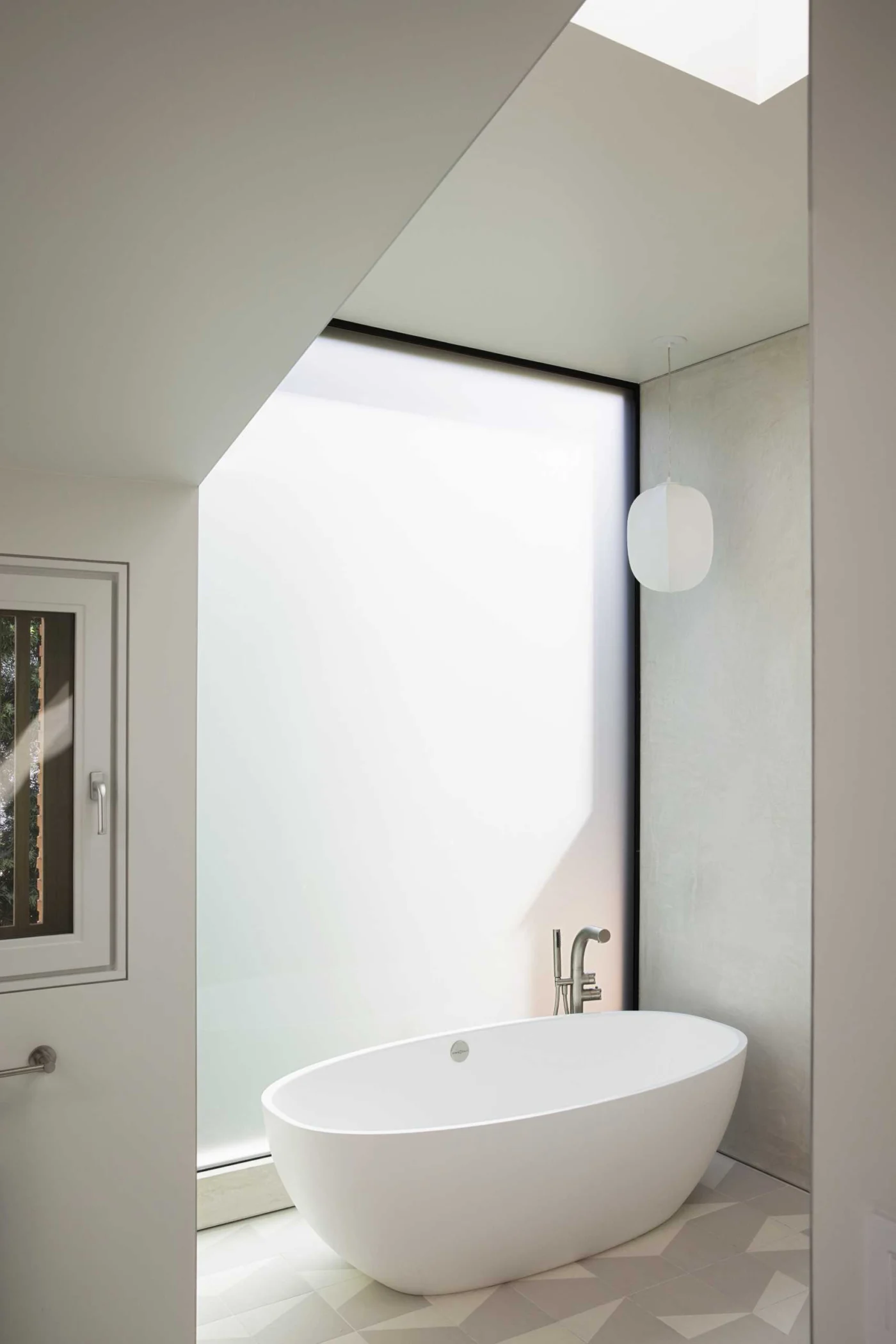Primary bathroom with a freestanding bathtub in front of a large window