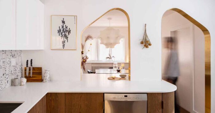 brass-lined-arches-connect-the-kitchen-with-the-dining-room-inside-this-home