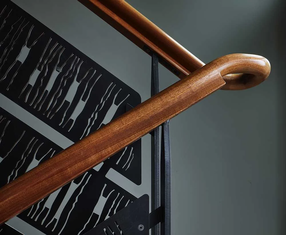 Wood handrail over a patterned steel balustrade