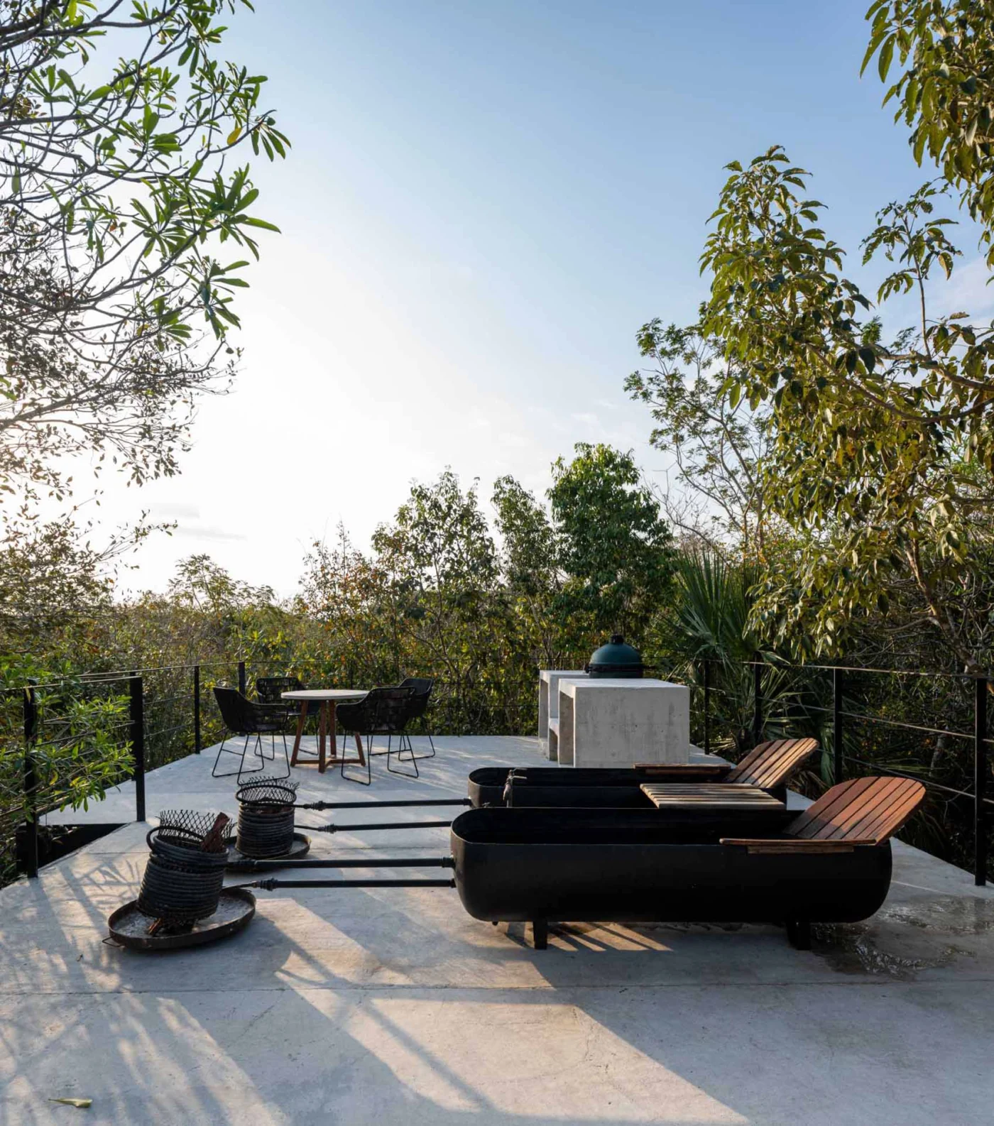 Rooftop of a glass house with two wood-fired tubs among the treetops