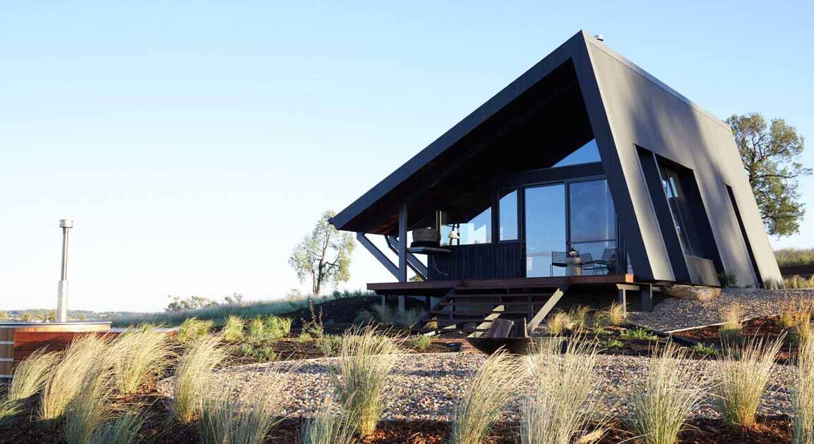 a-metal-roof-wraps-around-this-off-grid-cabin-to-protect-it-from-the-elements