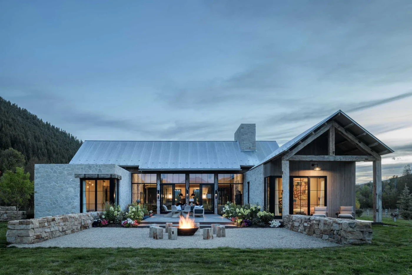 Rear courtyard with an outdoor fire pit and floor-to-ceiling windows into the living area