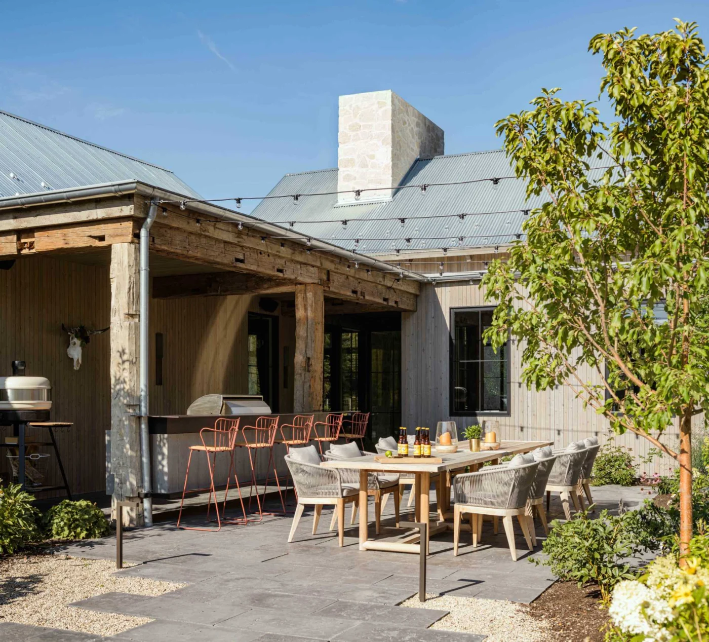 Outdoor kitchen and entertaining area on the side of the ranch house