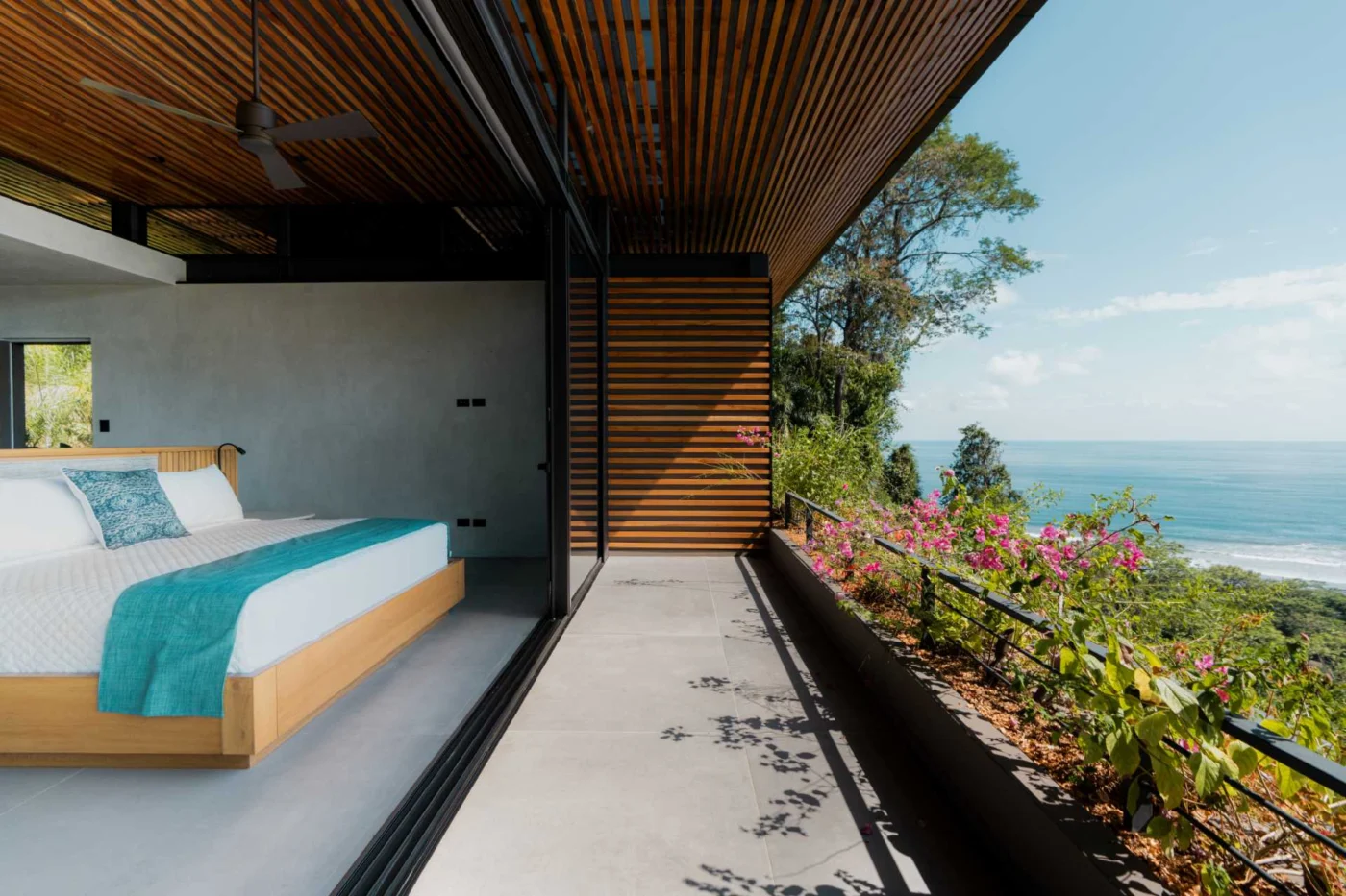 Bedroom opening onto a balcony with a view of the water