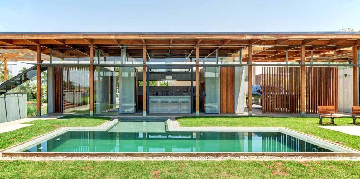 an-exposed-structure-shows-off-this-house-design-that-wraps-around-a-pool