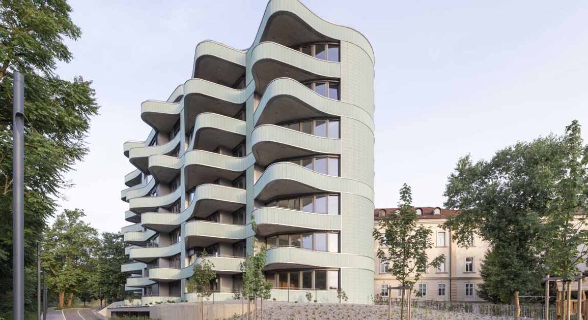 undulating-balconies-and-a-mint-green-tiled-exterior-give-this-new-building-a-unique-look