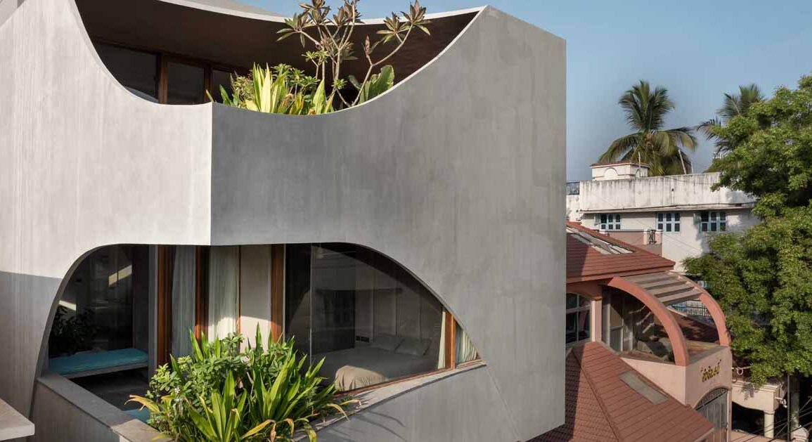 a-curvy-concrete-cube-with-cut-outs-for-windows-is-the-form-of-this-new-home