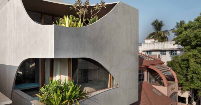 a-curvy-concrete-cube-with-cut-outs-for-windows-is-the-form-of-this-new-home